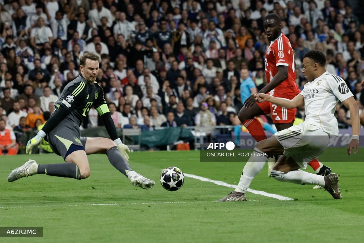 Goalkeeper making a save during a Champions League match, with players from both teams in action on the field. The scene captures the intensity of the game and the crowd in the background.